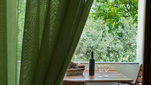 A dining area with a table and chairs, a bottle, and two glasses. - Sofia's House (Sithonia)