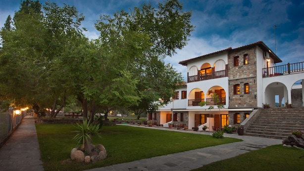 A two-story house with a stone facade, multiple balconies, and a well-maintained lawn. - Sofia's House (Sithonia)
