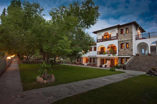 Vista frontal de la propiedad por la tarde o noche