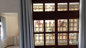 Habitación de hotel con un ventanal grande, una cama y vistas al exterior.