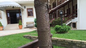 Un edificio con un porche cubierto, una escalera y un césped bien cuidado.