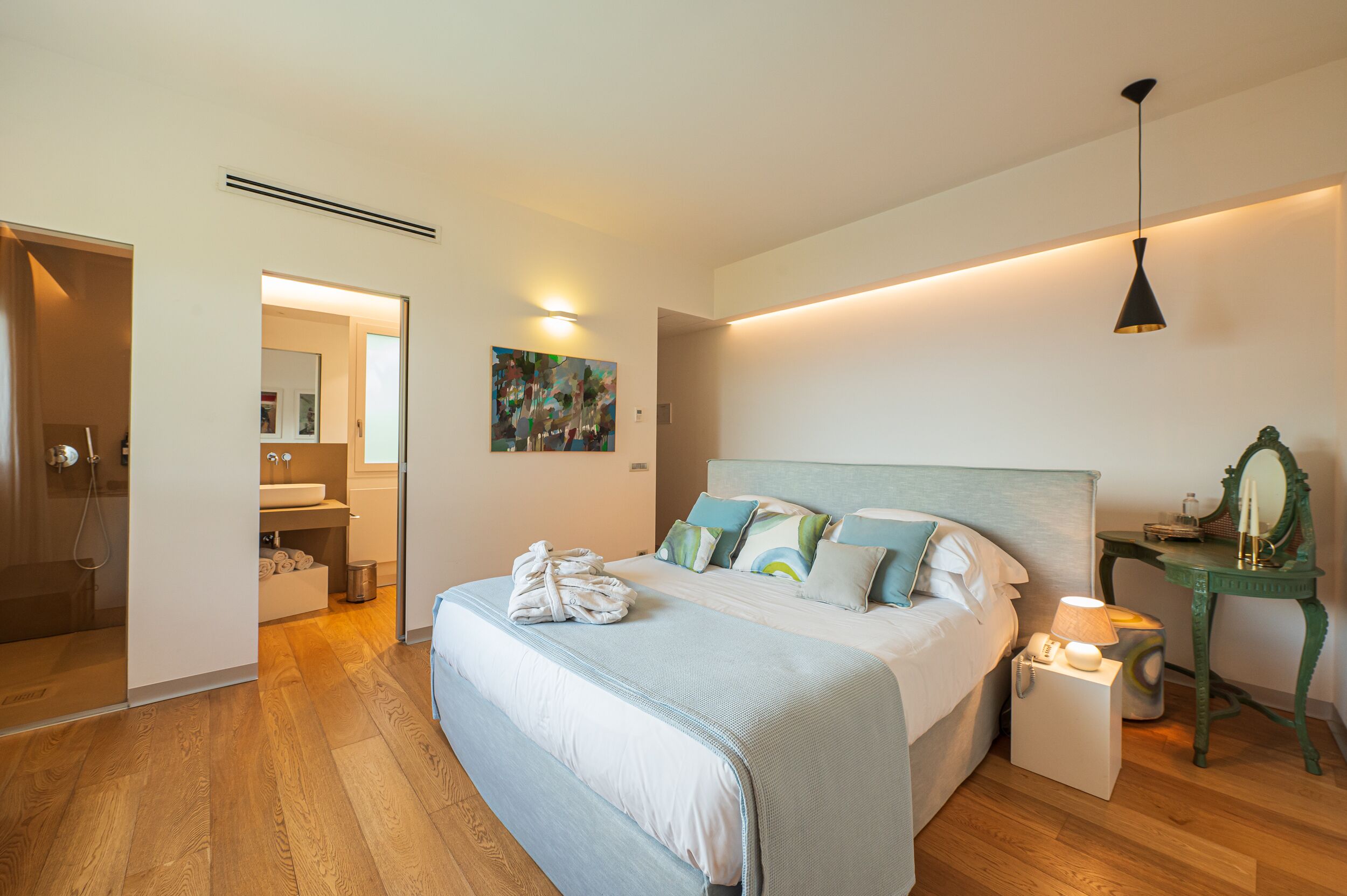 Un dormitorio moderno con una cama grande, una mesita de noche y una lámpara de noche.