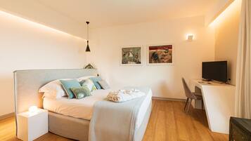 Ein modernes Schlafzimmer mit Bett, Nachttisch, Schreibtisch, Stuhl und Fernseher.