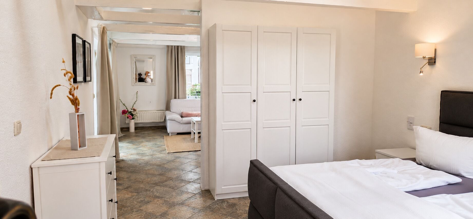Ein Schlafzimmer mit einem Bett, einem Nachttisch, einer Kommode und einem Kleiderschrank.