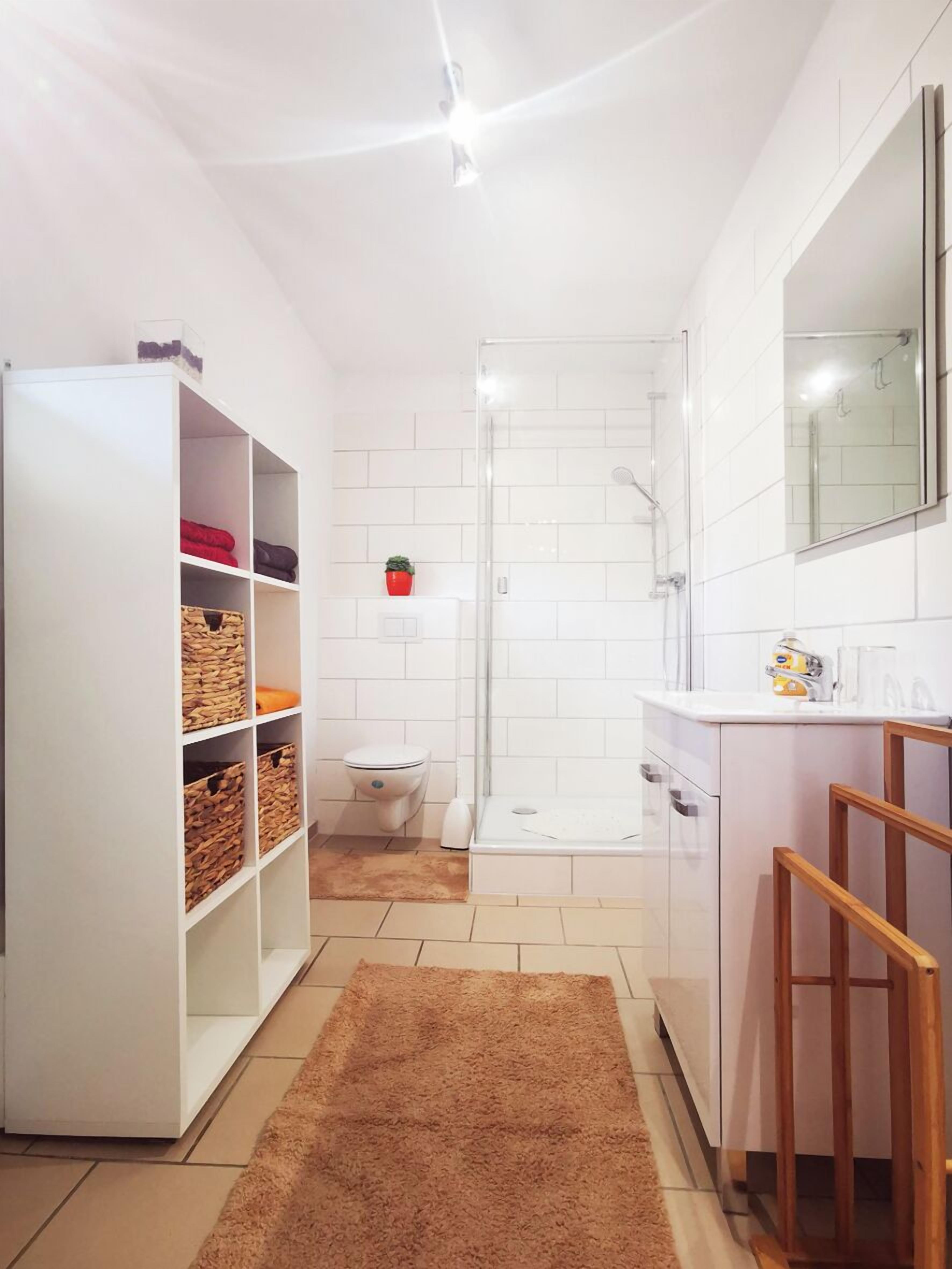 Un baño moderno con ducha, inodoro y lavamanos.