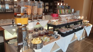 A buffet with various food items and beverages, including a coffee station and a selection of cheeses. - Hotel Garni Auszeit (Boltenhagen)