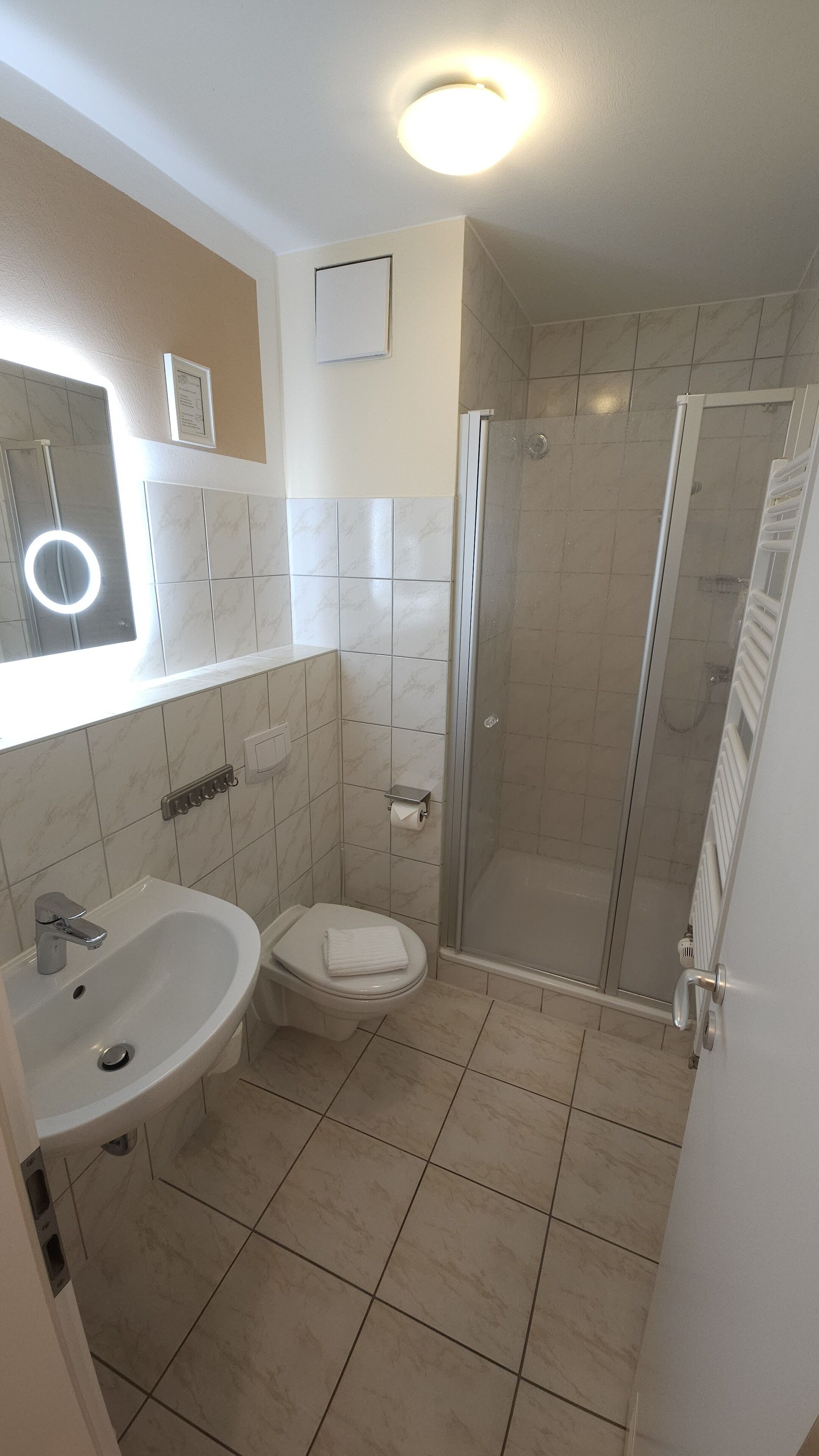 A bathroom with a sink, toilet, and glass-enclosed shower.