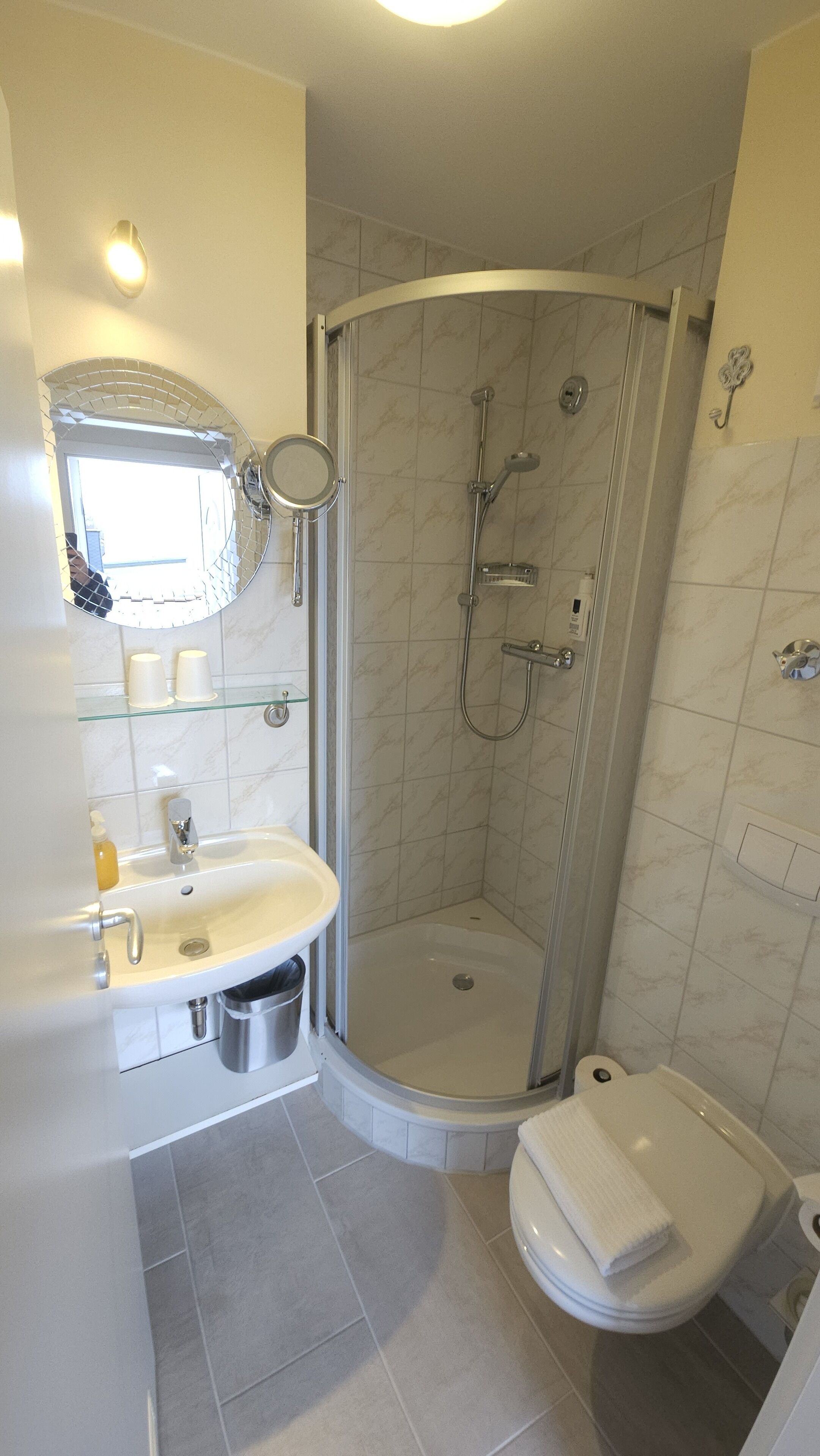 Une salle de bain moderne avec une douche à parois de verre, un lavabo blanc et des toilettes.