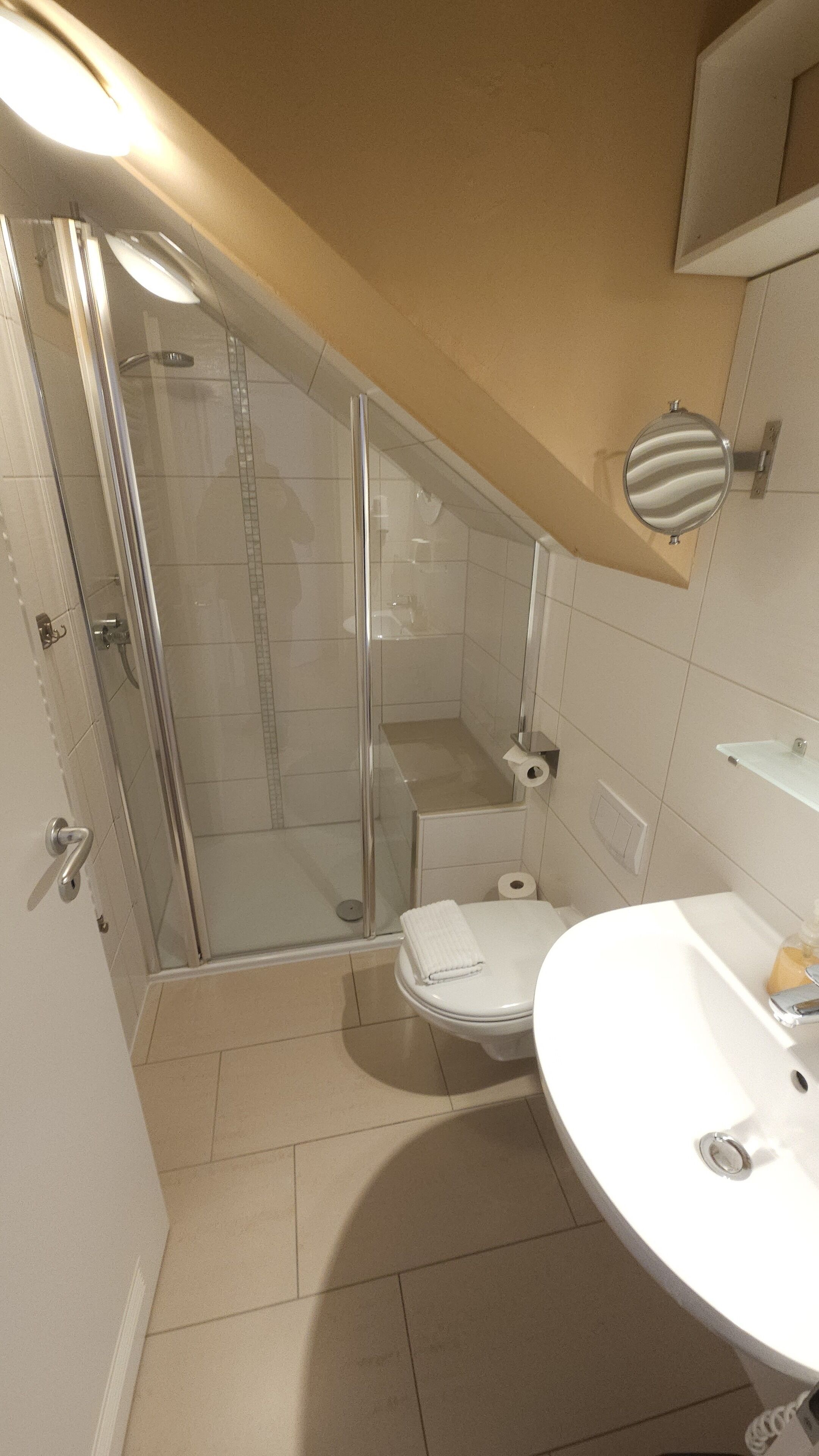 Une salle de bain avec une douche à parois de verre, des toilettes et un lavabo.