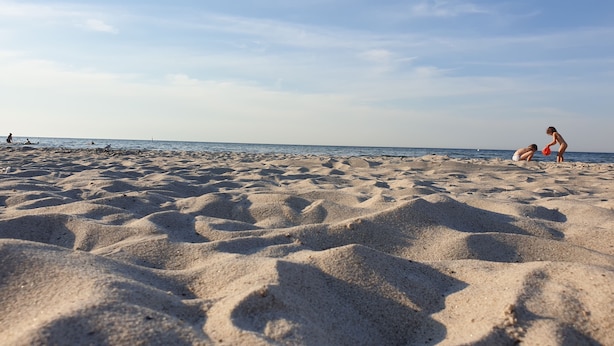 A sandy beach with people playing and walking. - Hotel Garni Auszeit (Boltenhagen)