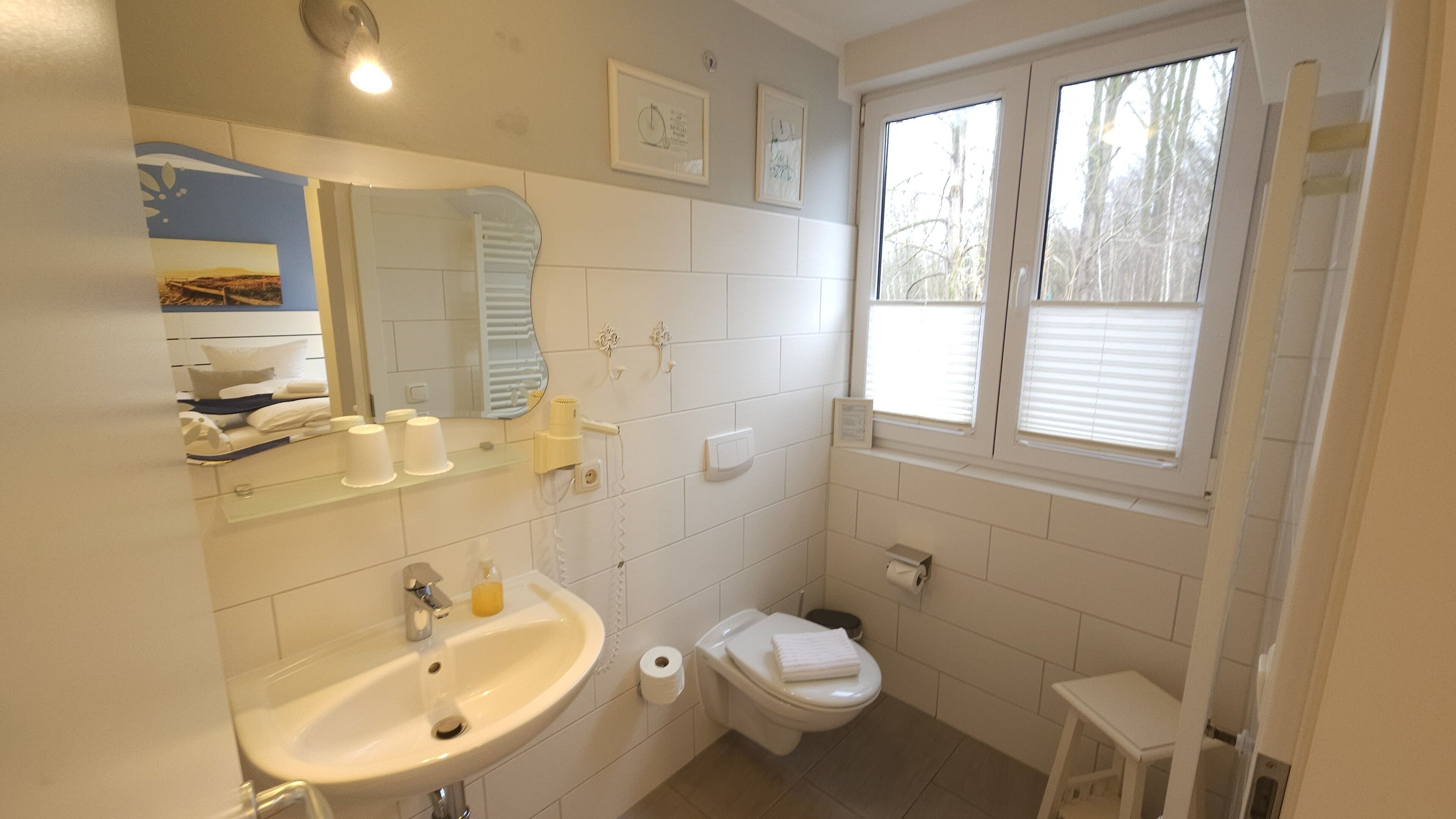 Un baño con lavamanos, inodoro y ventana.