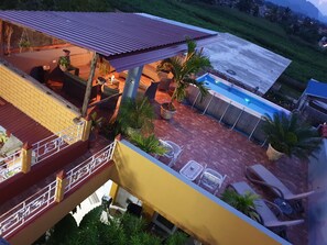 Een buitenzwembad, ligstoelen bij het zwembad