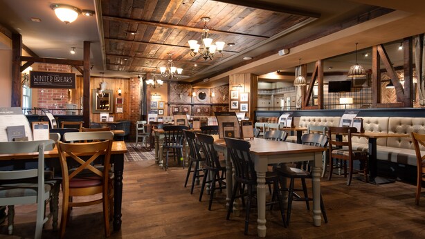 A restaurant interior with wooden floors, booths, and tables. - The Kingslodge Inn - The Inn Collection Group (Durham)