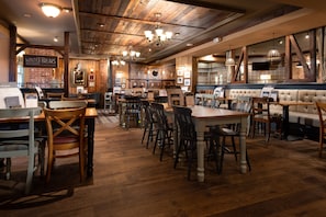 A restaurant interior with wooden floors, booths, and tables. - The Kingslodge Inn - The Inn Collection Group (Durham)