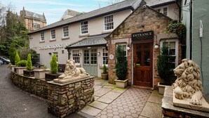 The Kings Lodge Inn entrance with stone lion statues, a stone wall, and a paved walkway. - The Kingslodge Inn - The Inn Collection Group (Durham)