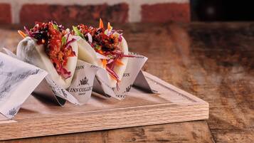 Two food items on a wooden board with a brick wall in the background.