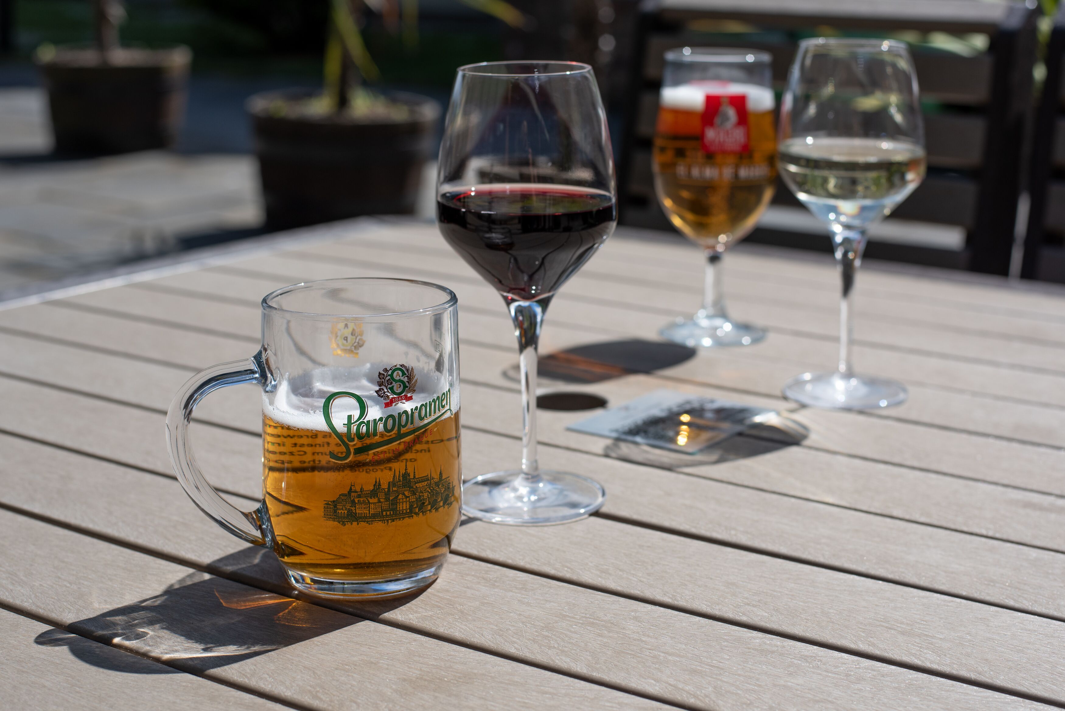 Una mesa con tres vasos de cerveza y vino.