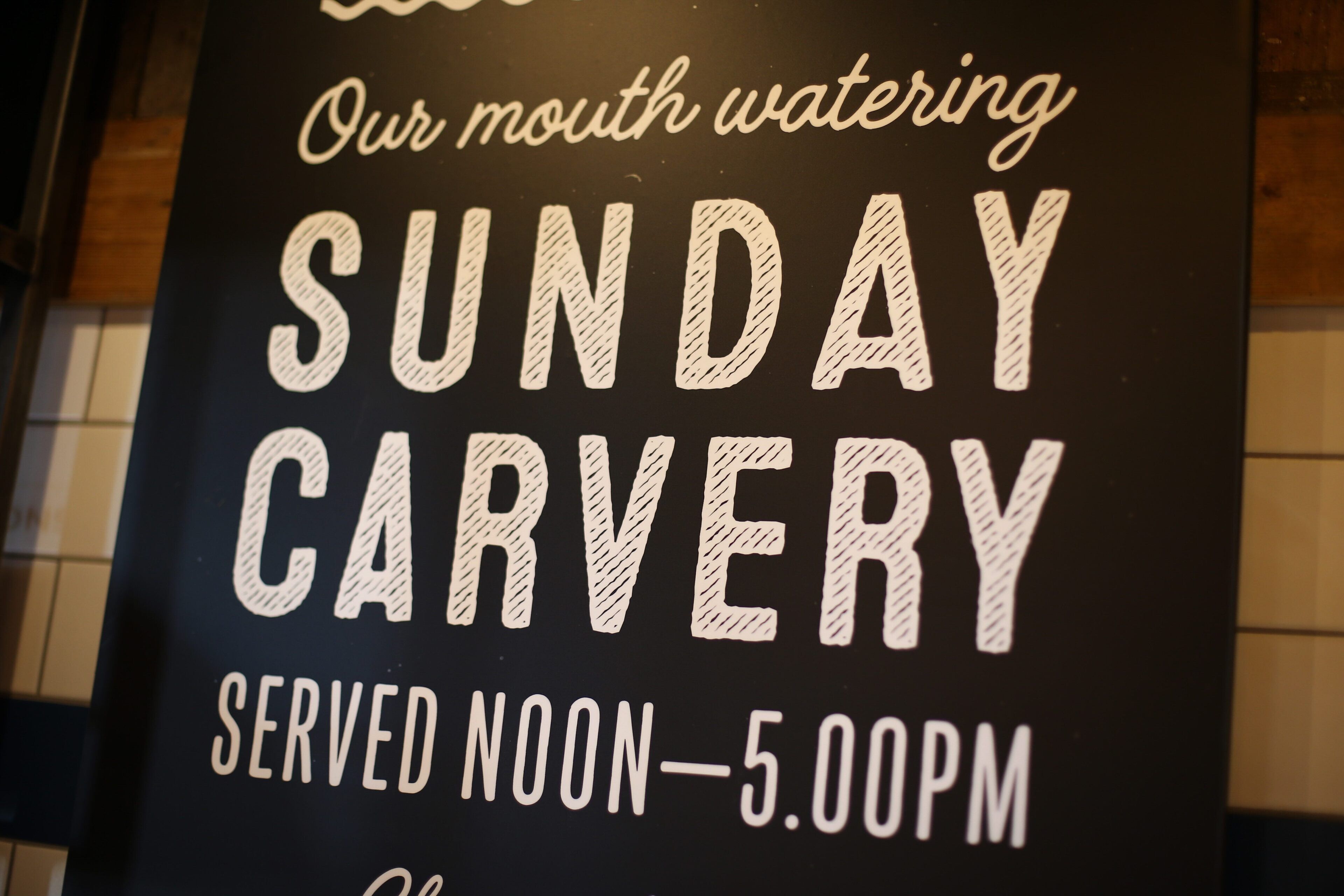 A sign for Sunday Carvery, a restaurant, serving from noon to 5:00 PM.