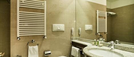 Ein modernes Badezimmer mit Waschbecken, Toilette und Handtuchhaltern.