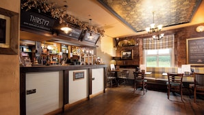 Un espace bar avec une enseigne sur laquelle on peut lire « SOIF ? » et un tableau affichant le menu. On y trouve des chaises en bois et une table d’où l’on peut admirer le paysage extérieur.