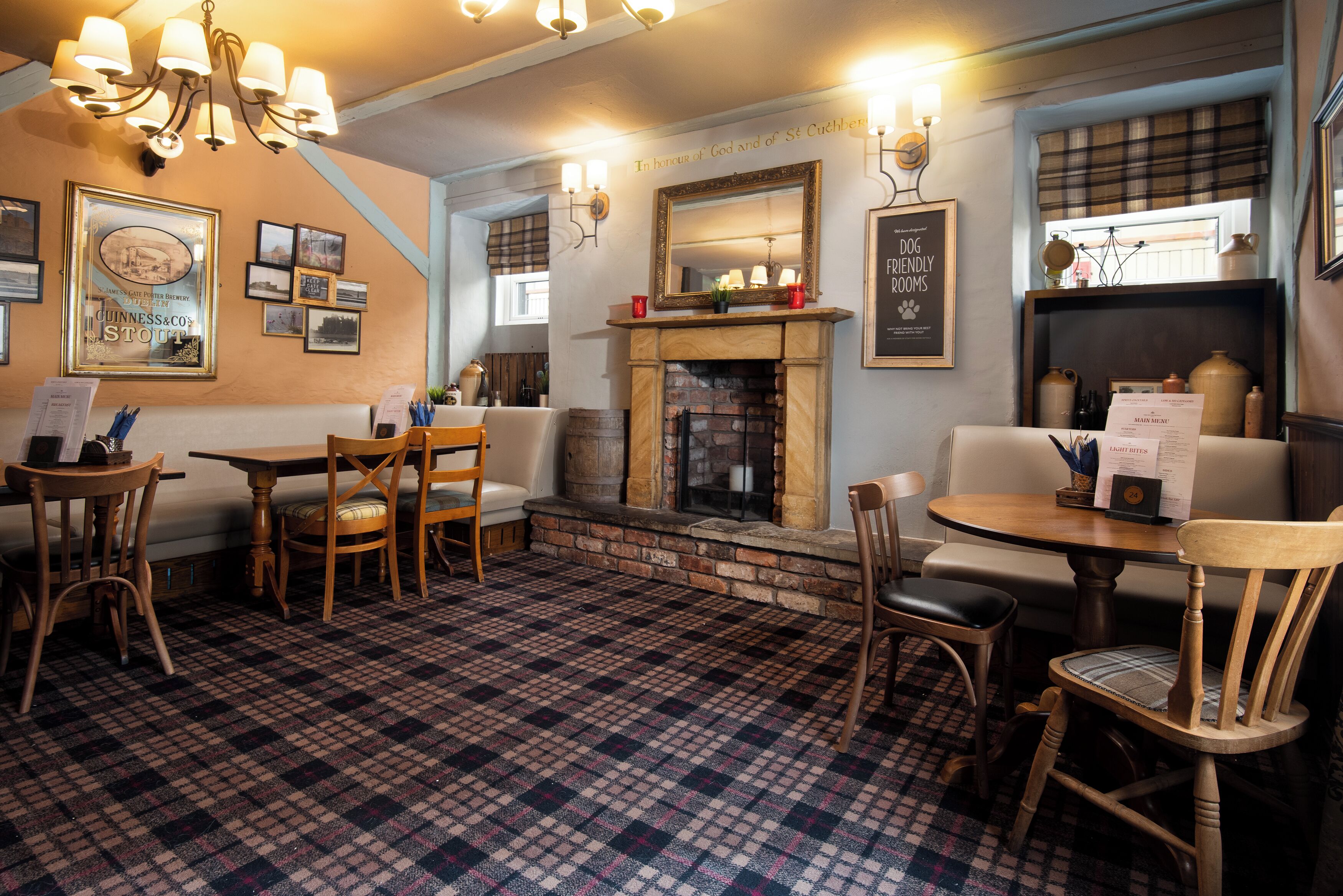 A cozy pub with a checkered floor, wooden furniture, a fireplace, and wall-mounted lights.