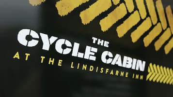 A logo with the text "The Cycle Cabin at The Lindisfarne Inn".