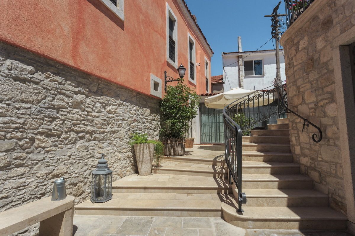 A stone staircase leading to a building with a wrought iron railing.