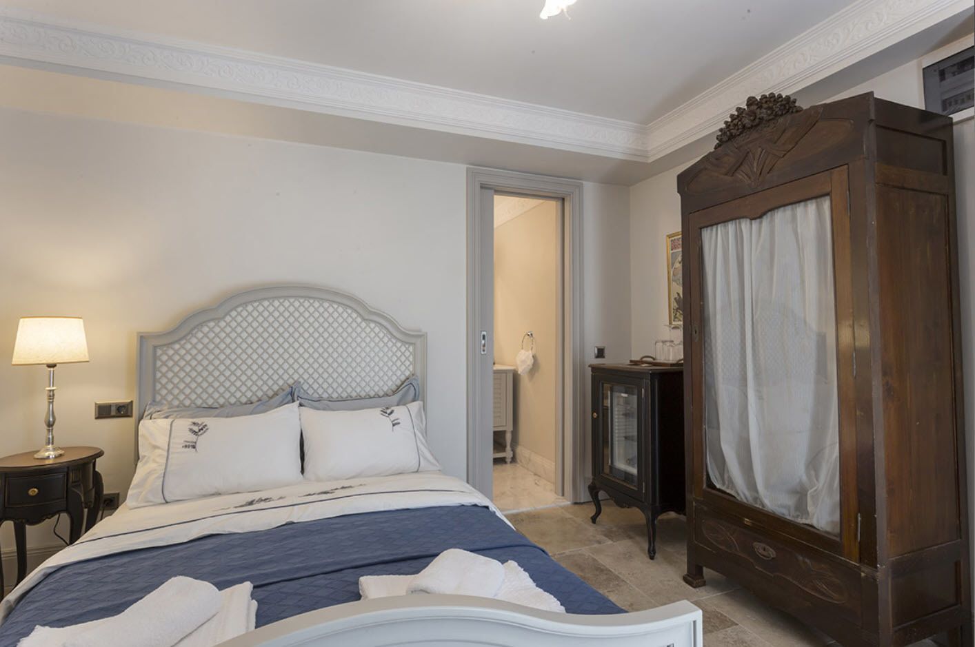 A bedroom with a bed, a nightstand, a dresser, and a wardrobe.