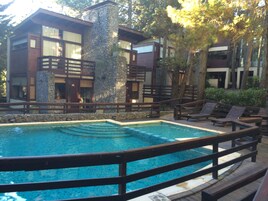 Una piscina al aire libre de temporada, sillones reclinables de piscina