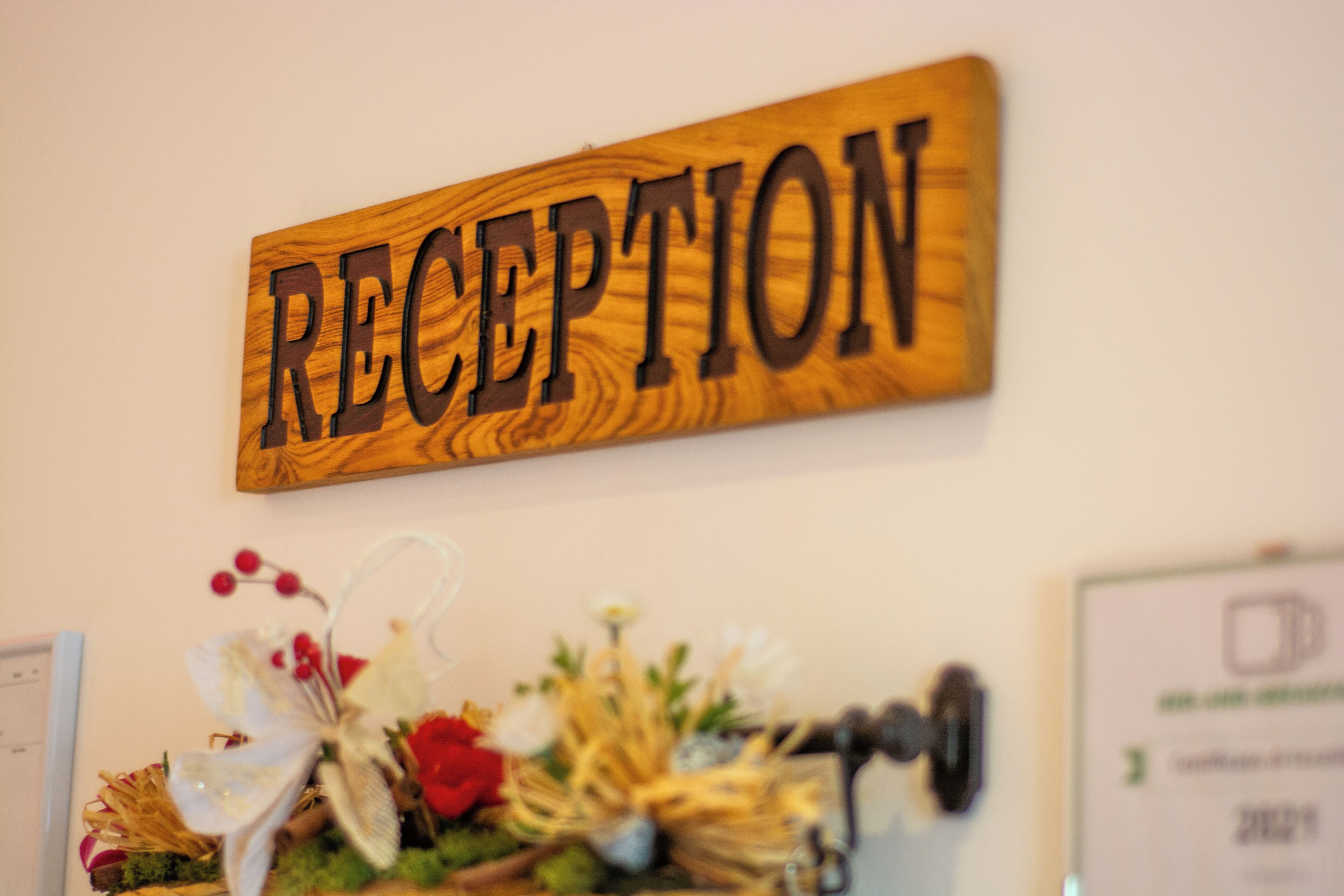 Un letrero de madera con la palabra 'RECEPTION' colgado en una pared.
