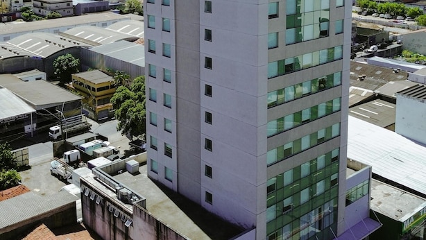A modern hotel building with a flat roof, multiple floors, and a sign indicating it is a hotel. - Transamerica Fit Serra (Serra)