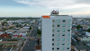 A high-rise hotel with multiple floors, a prominent sign for Transamerica Hotel, and a view of the surrounding urban area. - Transamerica Fit Serra (Serra)