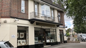 A two-story building with a ground-floor shop named "The Oxford Framing Gallery" and a balcony with a black railing. - The Manor Suite (Oxford)