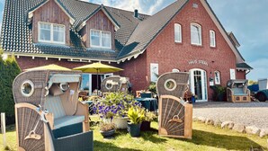 A two-story building with a red brick exterior and a tiled roof. - Haus Stern (Wangels)