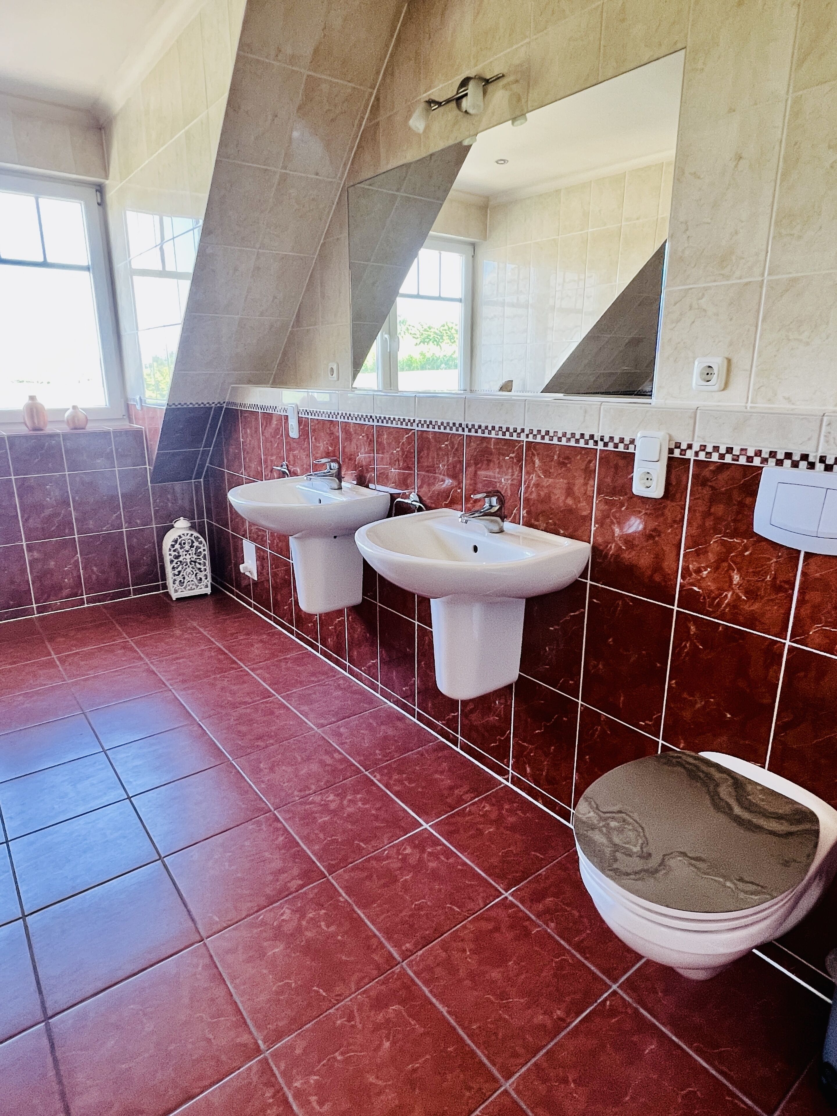 A bathroom with two sinks, a toilet, and a mirror.