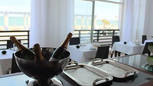 Un comedor con vista al mar, una mesa con cubo para champán y una bandeja.