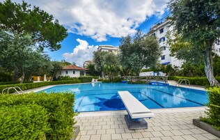 Una piscina al aire libre de temporada, sillones reclinables de piscina
