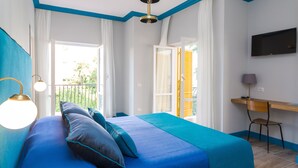Um quarto com uma cama, uma escrivaninha e uma televisão.