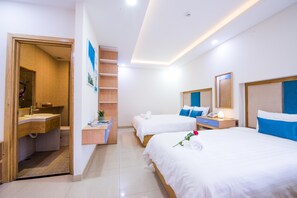 A hotel room with two beds, a bathroom, a wooden shelf, and a small desk. - Sincero Hotel & Apartment (Da Nang)