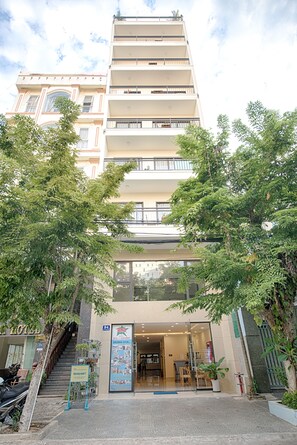 A hotel entrance with a staircase leading up to the entrance, a sign indicating the hotel name, and a glass door. - Sincero Hotel & Apartment (Da Nang)