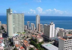 Un paisaje urbano costero con rascacielos, una vista despejada del océano y una combinación de edificios residenciales y comerciales.