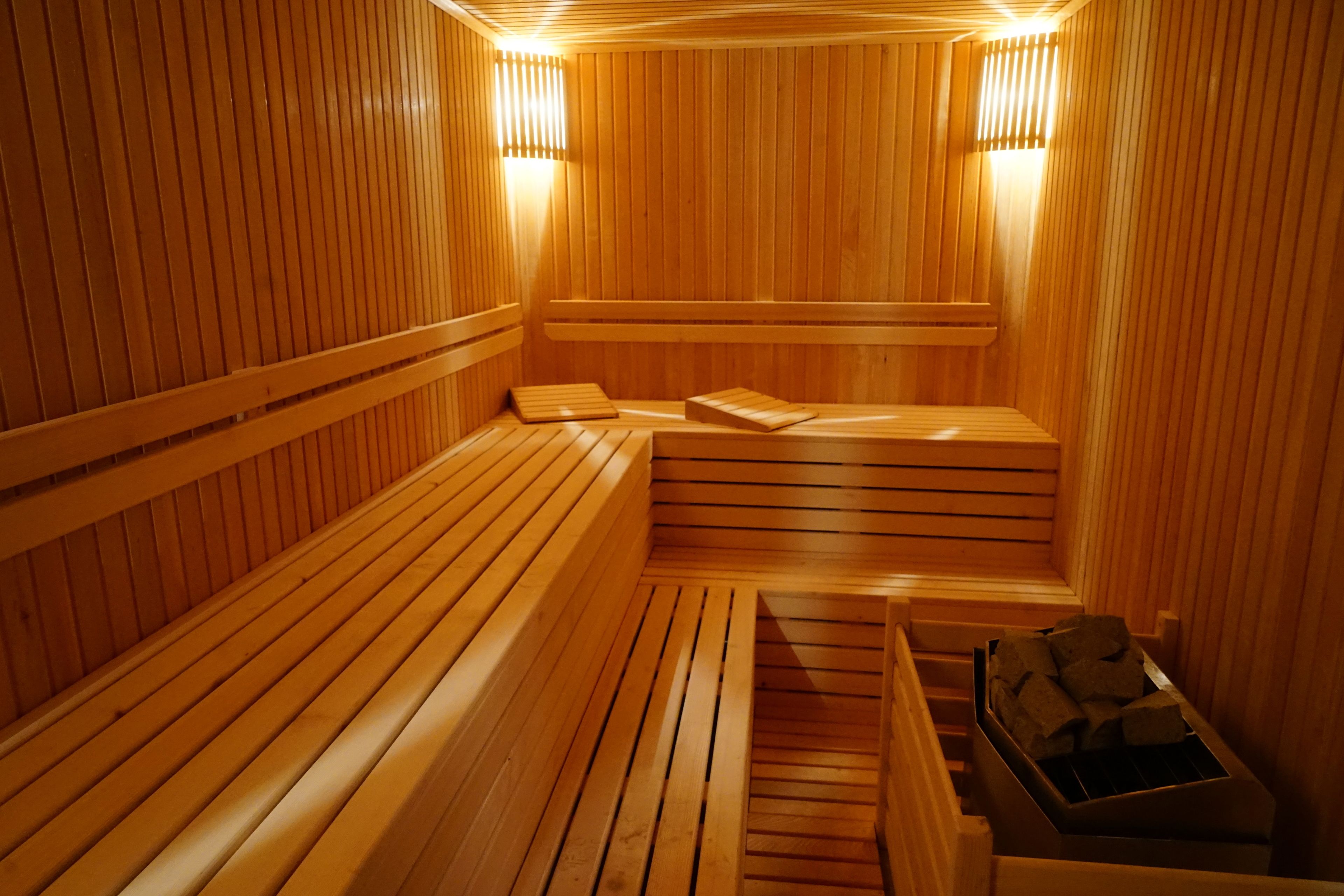 A wooden sauna with benches and a bench for sitting.