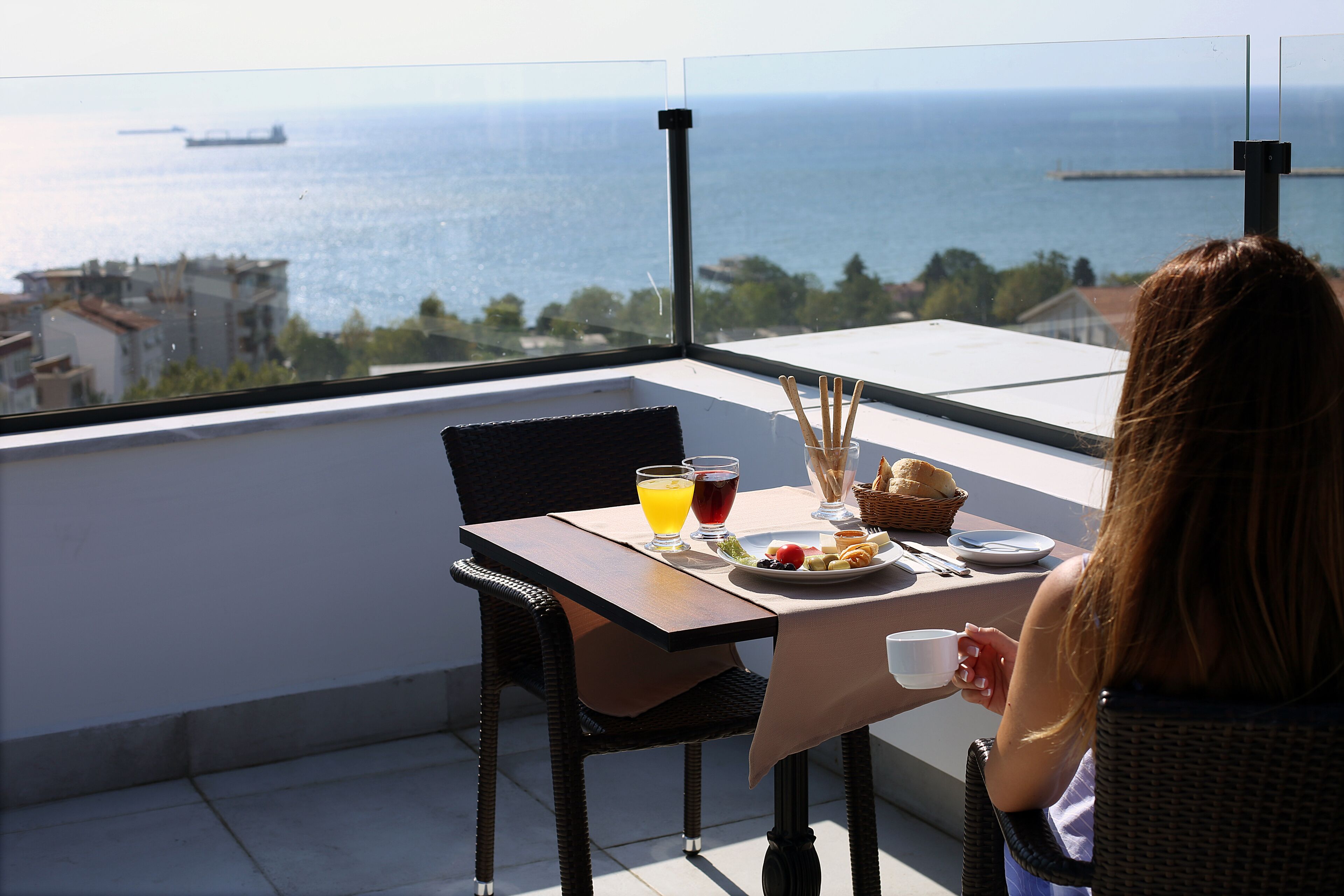 Un balcón con una mesa lista para el desayuno, con vista al mar.