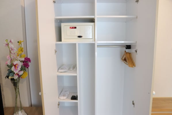 A white wardrobe with shelves, a hanging rod, and a control panel.