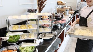 Una mesa de buffet con diversos alimentos y utensilios.