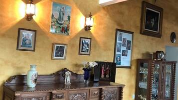 Una habitación con un armario de madera, lámparas fijadas a la pared y cuadros enmarcados.