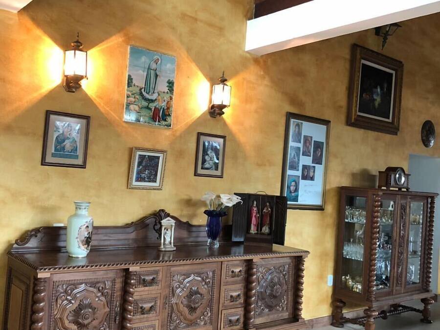 Una habitación con un armario de madera, lámparas fijadas a la pared y cuadros enmarcados.