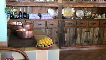 Uma cozinha rústica com armários de madeira, uma televisão e utensílios de cobre.