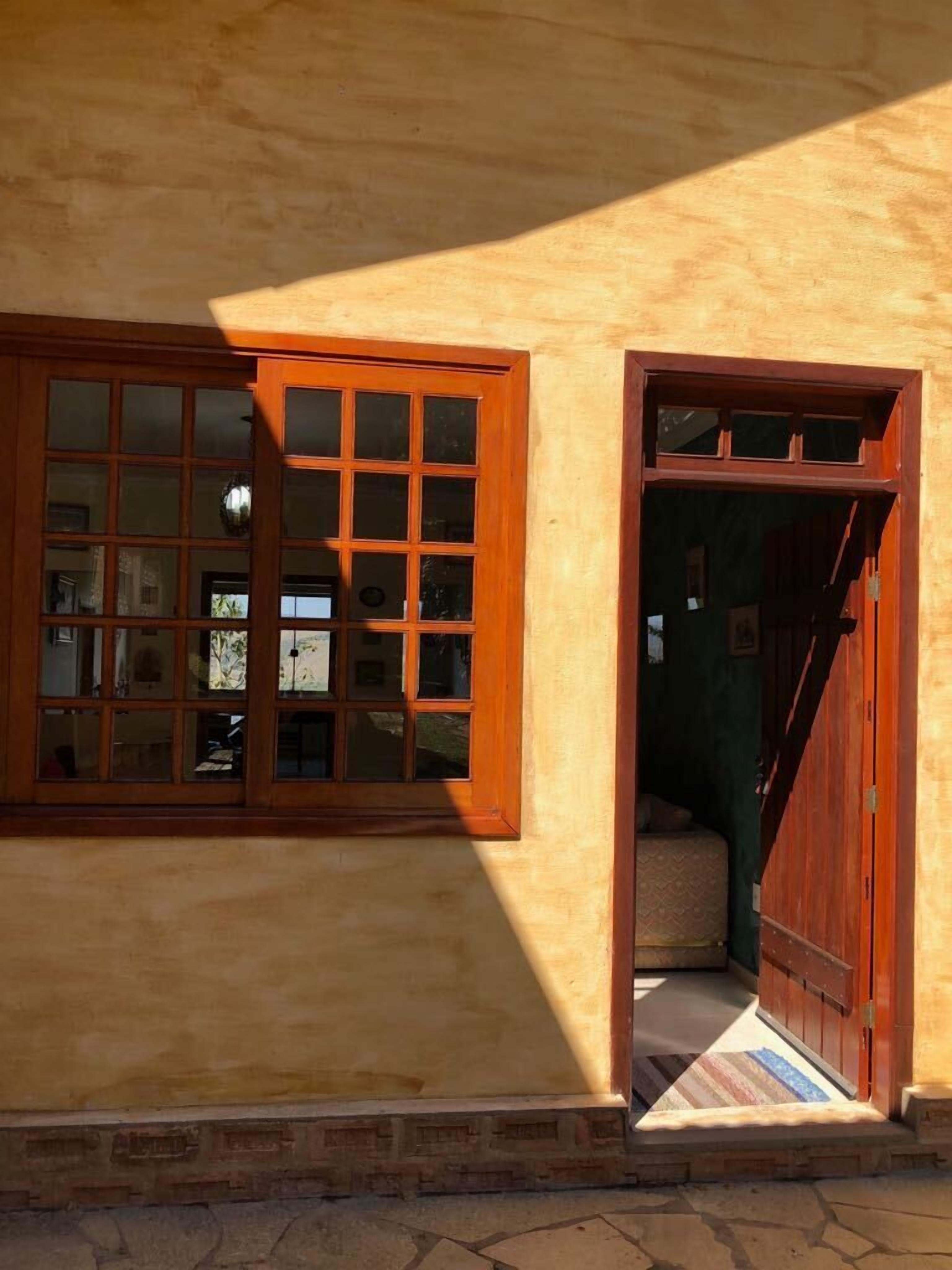 Un edificio con un amplio ventanal y una puerta que da a una escalera.