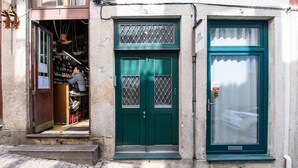 A building with a green door, a window with a curtain, and a cobblestone street. - Maria da Sé Historic House (Porto)
